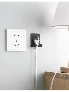 Close-up of matte black adhesive power plug hook for wall cable management