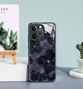 Detail of gray iPhone case with black ink flowers and gold foil flakes on white stand