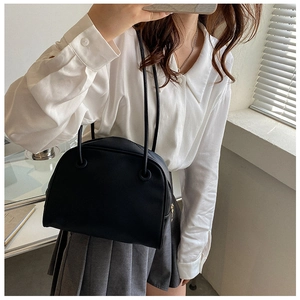 Classic black matte shoulder bag styled with a white shirt and pleated skirt outfit