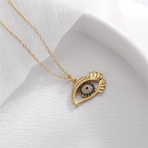 Close-up of golden Evil Eye pendant with blue rhinestones on a fine chain necklace