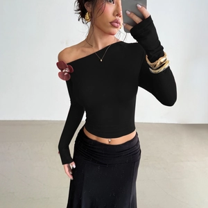 Close-up of vintage burgundy 3D rose detail on elegant black off-shoulder top