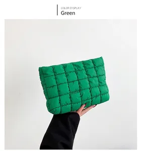 Detailed view of a green quilted cloud pouch held in hand showing soft padded texture