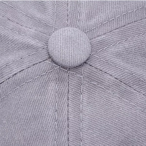 Macro detail of the grey washed cotton baseball cap top button and stitched seams