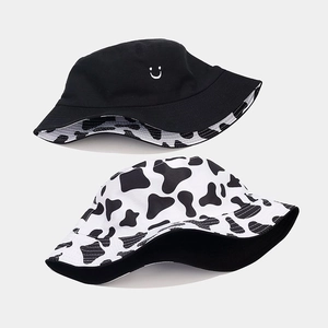 Detail showing reversible cow print pattern and black side with embroidered smiley face