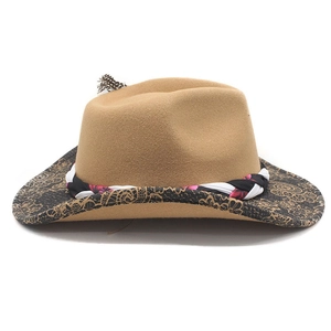 Detail of camel felt fedora with patterned brim and feather trim on woven band