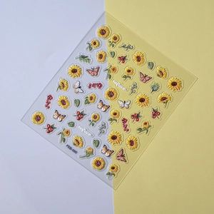 Macro view of 3D embossed sunflower and butterfly nail stickers on transparent base