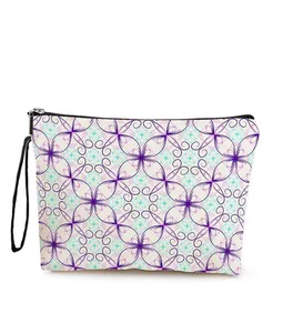 Detail showing the purple geometric floral pattern on a canvas cosmetic bag with zipper