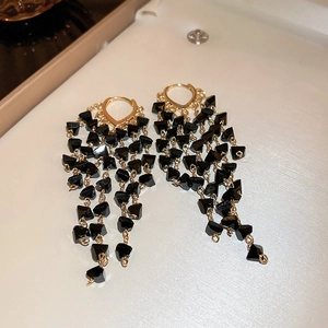 Luxurious long tassel drop earrings with black faceted beads and gold chain tassels