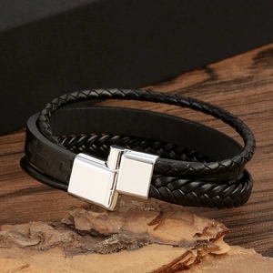Detail of multi-layer black leather woven bracelet with silver magnetic metal clasp