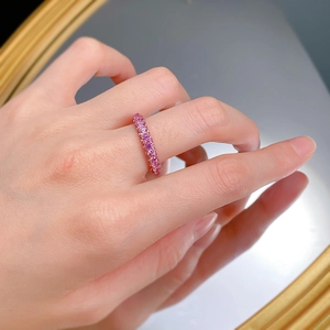 Macro view of a luxury full-circle ring featuring pink purple stones in claw setting