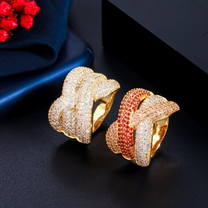Dettaglio macro di anelli larghi placcati oro con micro-pavé di zirconi bianchi e colorati