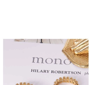 Detailed view of gold plated ring with pavé crystals on white card background
