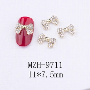 Détail macro de breloques nœuds dorés pour nail art avec strass en taille 11x7,5mm