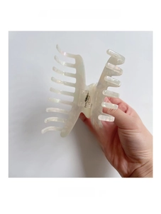 Detailed view of large cream acetate hair claw clip with pearlescent iridescent finish