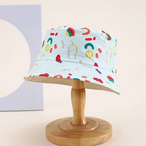 Chapeau bob enfant bleu clair avec graffitis colorés sur support en bois