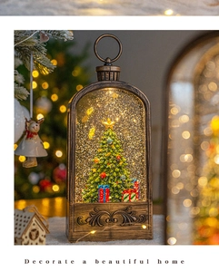 Detail of vintage bronze Christmas snow lantern with lighted pine tree and glitters