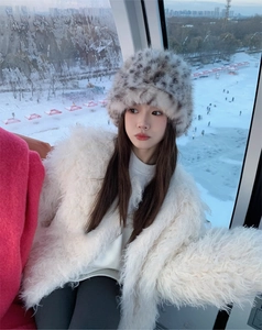 Detailed close-up of fluffy leopard print plush bucket hat and white faux fur coat