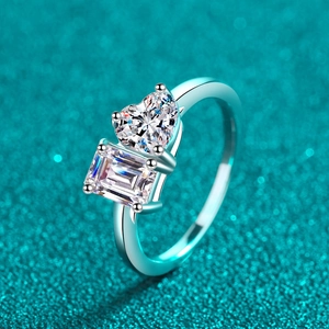 Elegant silver two-stone ring featuring heart and emerald cut crystals on green background