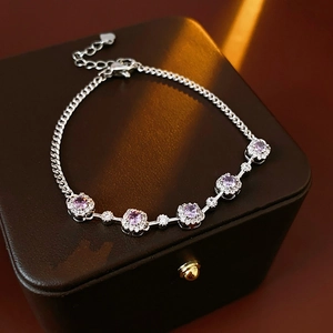 Macro shot of silver bracelet featuring purple oval zircons and micro-pave white crystals