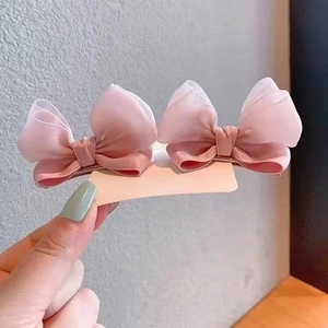 Close-up of pink jelly yarn bow hair clips for babies with soft ribbon and organza detail