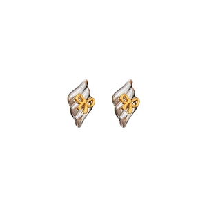 Minimalist silver wavy textured earrings with a golden bow accent on white background