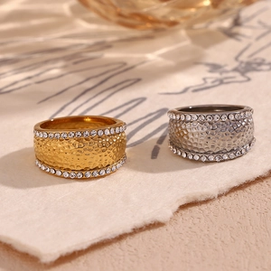 Close-up of gold and silver hammered texture wide rings with crystal inlay details
