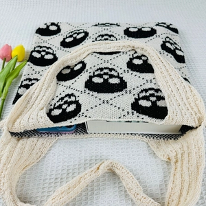 Top view of skull pattern knit tote bag showing interior storage with phone and book