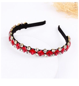 Detailed side view of luxury headband with red crystals and diamonds on black velvet