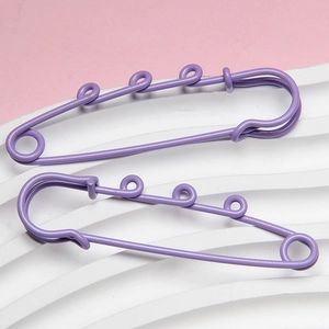 Detail of two purple 6cm safety pins with three loops for DIY jewelry and waist adjustment