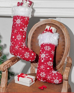Detail of red Christmas stockings with white snowflake embroidery and plush faux fur trim