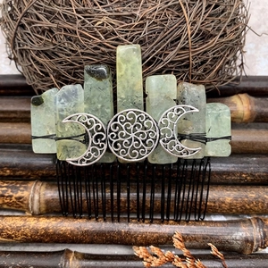 Macro detail of natural green crystal hair comb with silver crescent moon motif