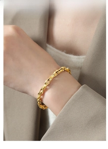 Close-up of gold plated chunky twist rope chain bracelet worn on a woman wrist