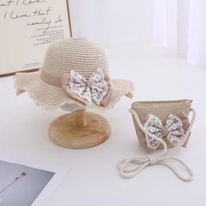Detail of girls straw sun hat and matching crossbody bag set with lace bow
