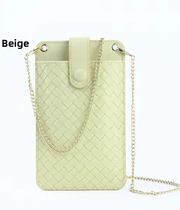 Vue détaillée du petit sac à téléphone jaune crème avec texture tressée et chaîne