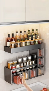 Detail view of wall-mounted black kitchen spice rack with tiered storage and drawers