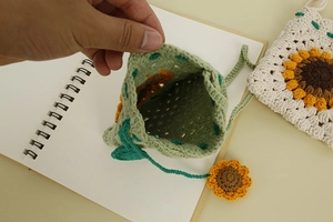 Detailed view of the interior space and crochet texture of this floral knit crossbody bag