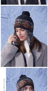Detailed knit texture of a winter trapper hat with orange patterns and faux fur pompom