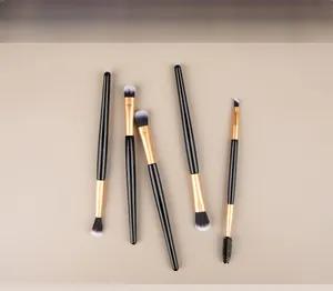Close-up of dual-ended makeup brush set with black handles and golden ferrules