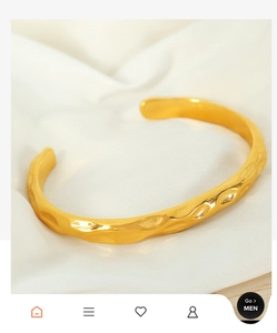 Detailed view of irregular hammered texture on a vintage gold-plated C-shaped cuff bracelet