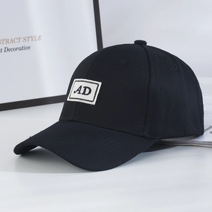 Detailed view of black cotton baseball cap with white AD embroidered patch on the front