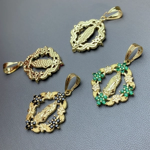 Gold Guadalupe pendants with green and black cubic zirconia in a studio layout