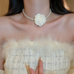 Detail of elegant French retro pearl necklace featuring a large white fabric flower charm