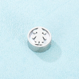 Macro detail of a silver stainless steel bead featuring a hollow girl silhouette pattern
