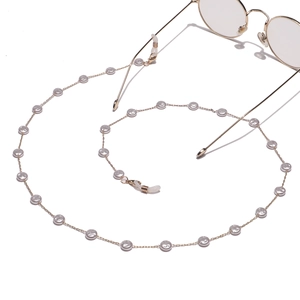 Gold glasses chain with round pearls and non-slip rubber loops on white background