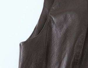 Dettaglio macro della texture in finta pelle marrone scuro con cuciture di alta qualità