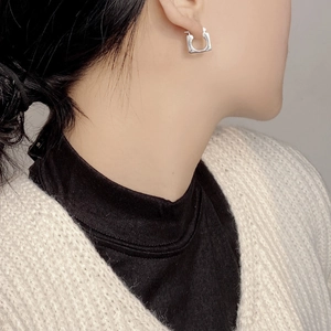 Minimalist 925 sterling silver square hoop earrings worn by a model in a side view style