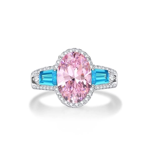 Macro-opname van een ovale roze edelsteenring met blauwe zijstenen en pavé gezette diamanten