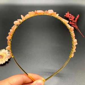 Detailed close-up of handmade gold wire crown headband with peach crystal stones