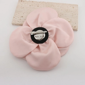 Macro detail of the back showing the pink fabric flower petals and silver metal duckbill clip