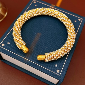Vue rapprochée du bracelet jonc ouvert serti de cristaux sur un coffret cadeau bleu